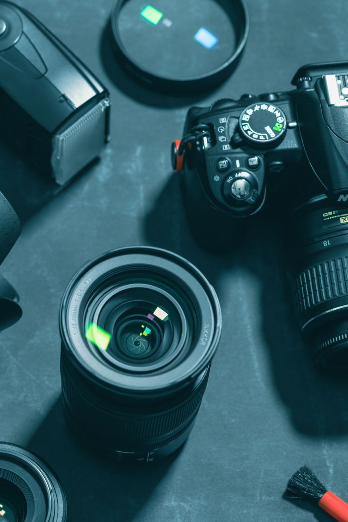 about-02 Close-up of DSLR camera and lenses on dark background, highlighting photography gear essentials.